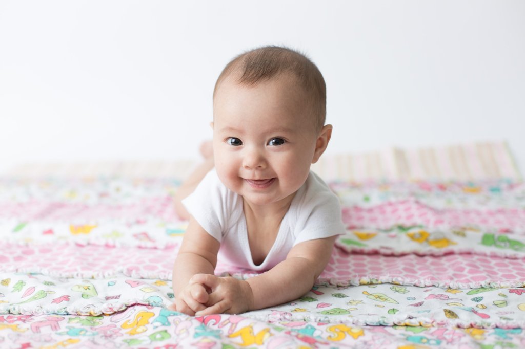 Baby laying on a hand sewn blanket. 